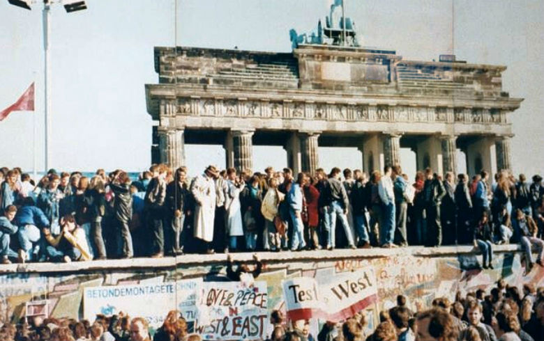 Multidão comemora sobre o Muro que separou os alemães por décadas